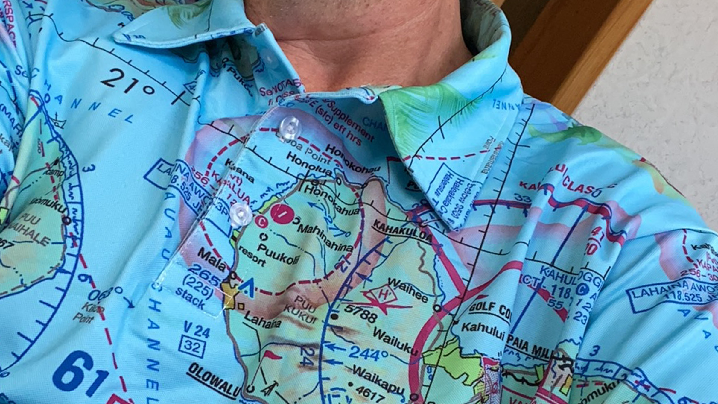 Blue polo shirt decorated with Hawaii VFR sectional chart for pilots with palm trees